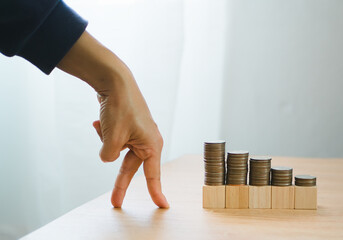 business and finance growth concept. Fingers walking up on coins stack and row of coin. collecting money, financial planning, save money for the future. - obrazy, fototapety, plakaty