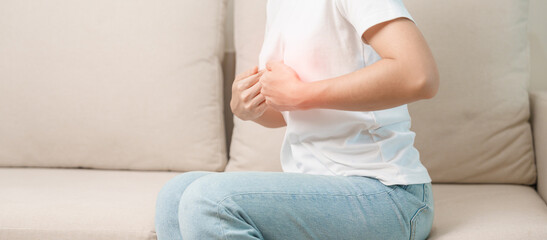 woman having abdomen ache due to Stomach pain, digestion with constipation or Diarrhea from food poisoning and liver cancer on the sofa at home