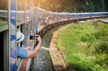 Man tourist using mobile phone taking photo of rail way