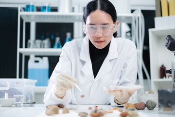 Close up of geologist or archaeologist is looking and focusing on a sample of rock, stone or...
