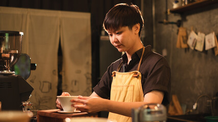Female Barista is prepare filter coffee equipment in loft coffee shop or cafe bar. Concept of slow bar, pouring coffee caffeine, traditional making process of coffee maker. Black and brown style.