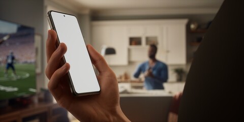 Caucasian male watching football at home with friends, making bets on his phone