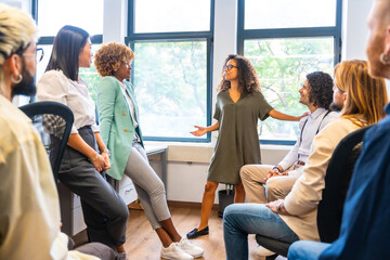 Woman talking in front of coworkers in a office