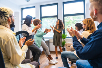 Colleagues congratulating an african woman in a coworking