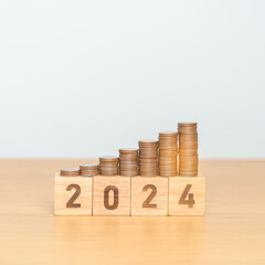 2024 year block with Coins stack. Money, Budget, tax, investment, financial, savings and New Year Resolution concepts