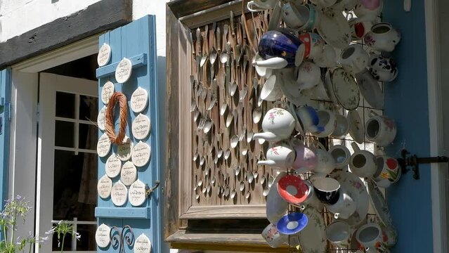 Multicolored faience and porcelain cups and mugs on wall of cafe shop