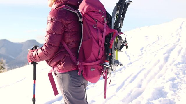 climber walks through the snow, climbing a mountain, winter hike, man in the mountains in winter, hiking equipment, backpack and snowshoes.