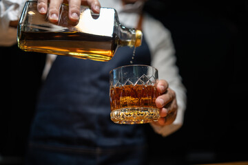 Barman pouring whiskey whiskey glass..