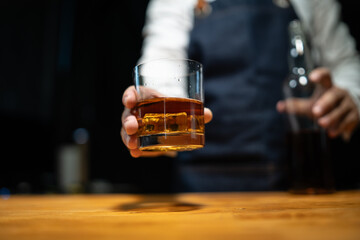 Barman pouring whiskey whiskey glass..