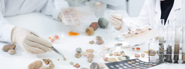 Concept of geologist or archaeologist is analyzing a sample of rock or mineral in paleontology, archaeological and geological or mining laboratory background or banner. Fossil stone or soil experiment