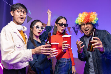 Happy asian diverse group friends celebrating with beer bottles and clinking on party. Home party friends  having fun enjoying time and dancing together. New Year's Eve Party concept