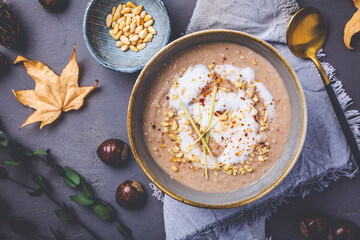 Homemade sweet chestnut soup with coconut milk, chili, lemon grass and pine nuts