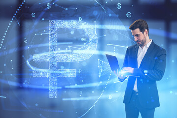 Attractive young european businessman using laptop with glowing digital blue ruble hologram on blurry office interior background. Business finance and money exchange concept. Double exposure.