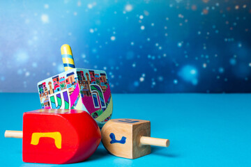 Hanukkah blue greeting card, invitation with wooden dreidels, Jewish Festival of light holiday.