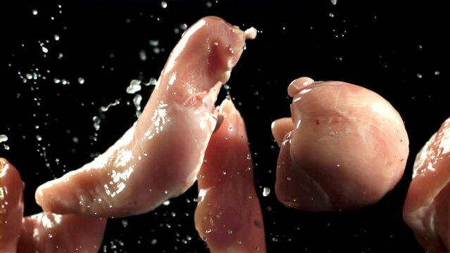 Raw chicken fillet flies up with splashes. Filmed on a high-speed camera at 1000 fps. High quality FullHD footage