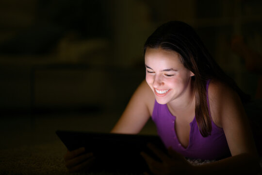 Woman using tablet in the dark