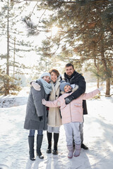 Happy family in the winter forest. High quality photo. A happy family hugs, runs, lies in the snow. Have fun together
