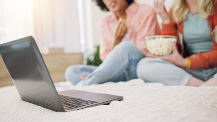 Laptop, movie and women friends on a bed with popcorn for comedy, program or film in their home....