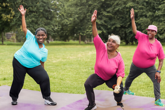 grandmothers do exercises. sporty grandmothers in nature on the grass on mats in tracksuits bend to the side