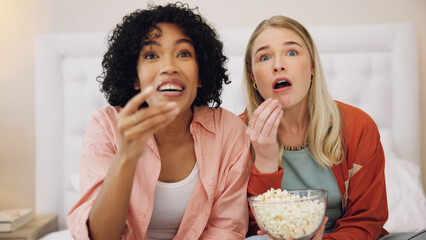 Horror, television and women friends with popcorn on bed for scary, movie or serial killer documentary at home. Watching tv, face and ladies in bedroom with terror, film or video, snack and streaming