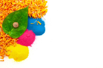A top view of a betel nut, placed on a betel leaf (paan) with orange marigold petals and rangoli...