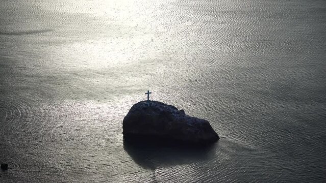 Snow covered rocky cliffs over sea. Winter landscape over the sea bay. Juniper tree under snow. Concept of winter holidays, travel and recreation. Cape Fiolent in Balaklava, Sevastopol, Crimea