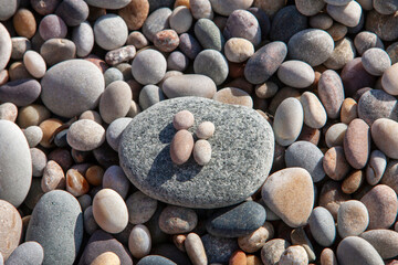 Wet rolled round Beach Pebbles stones in the form of people, natural background, texture
