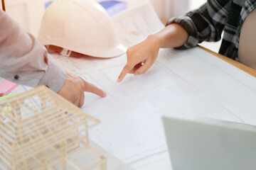 Close up of engineer hands discussing a building construction project with blueprint draw and...