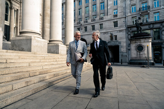 Businessmen walking together near financial buildings