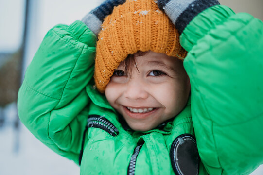 Happy boy wearing yellow knit hat in winter