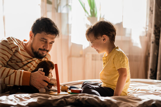 Man spending leisure time with son playing at home