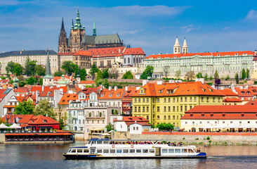 Obraz premium Lesser town (Mala Strana) cityscape with Prague Castle and cruise boat on Vltava river, Czech Republic
