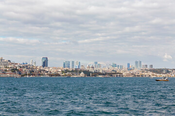 Fototapeta premium Istanbul panorama as seen from Bosphorus and Kadikoy. Sunny october day, beautiful clouds, Sisli towers at skyline. October 17, 2022 - Istanbul, Turkey