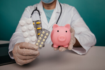 Doctor's hands with piggy bank and pills