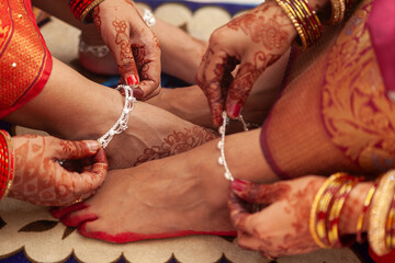 Indian Wedding Concept. Two women at an Indian wedding, wearing Silver anklets (Payal) and showing...
