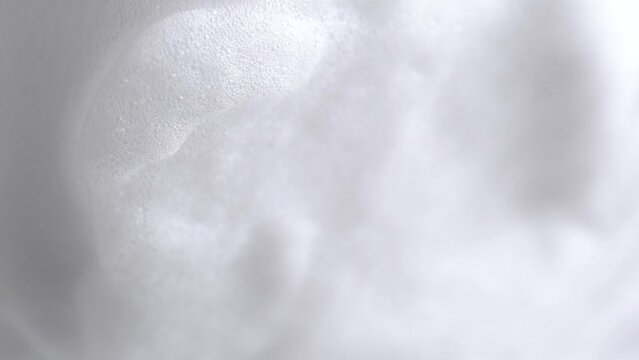 Hair foam mousse, macro. Beauty background. Close up of white cloud of hair mousse or shaving foam. Soap suds