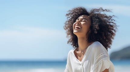black woman on the beach and laughing at the ocean