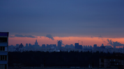 Fototapeta premium view of city buildings in distance against sky during sunset