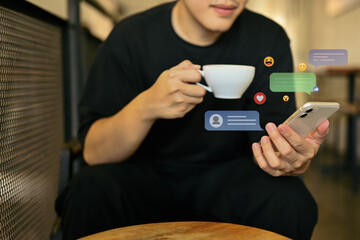 Cropped shot of man drinking coffee and using mobile phone for commenting in online community