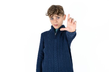 Caucasian teen boy making fun of people with fingers on forehead doing loser gesture mocking and...