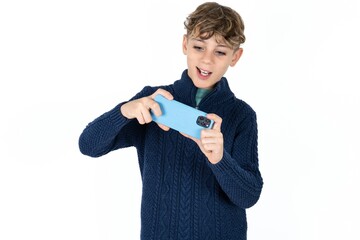 Portrait of an excited Caucasian teen boy playing games on mobile phone.