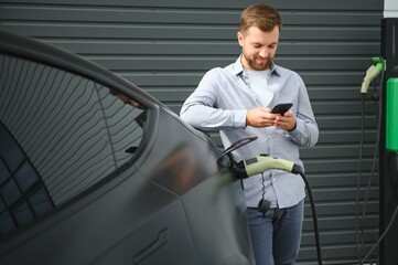 a man charges an electric car