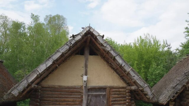 Ancient Wooden Slavic House with a skull - Biskupin, Poland - tilt down shot.