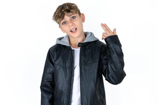  caucasian kid boy wearing black jacket foolishness around shoots in temple with fingers makes suicide gesture. Funny model makes finger gun pistol