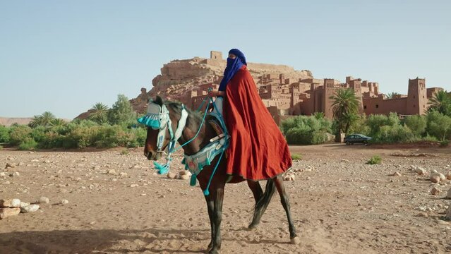 Man rearing his horse in front of Ait Benhaddou old town, Morocco