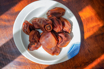 Diospyros kaki fruit or Persimmons are exposed to the sun and natural wind like the Japanese and Korean Hoshigaki method, Da Lat, Vietnam. Hong Treo Gio