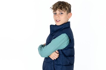 Portrait of  caucasian kid boy wearing blue vest  standing with folded arms and smiling