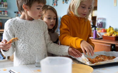 Three children eating homemade pizza