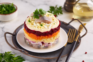 Dressed herring fish layered salad with boiled eggs and vegetables: potato, carrot and beetroot. Herring under a fur coat.