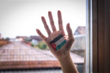 Hand painted with Palestinian flag behind the window. Freedom and colonialism concept - obrazy, fototapety, plakaty